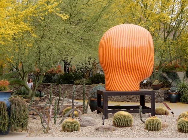 Ceramic head by Jun Kaneko surrounded by golden barrel cactus.